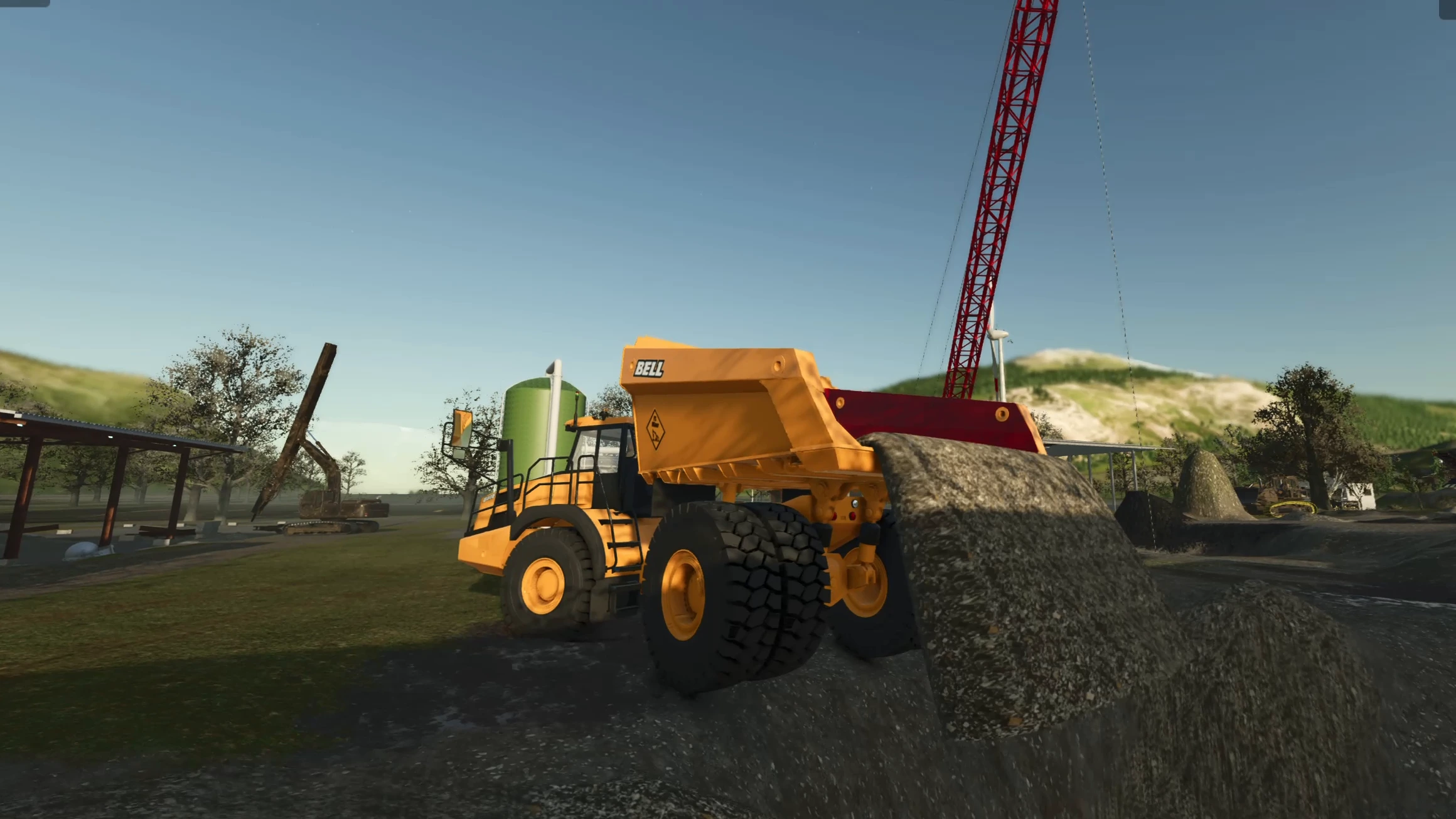 Bell dump truck with its bed raised, the material pouring out and turning straight into an embankment instead of a heap