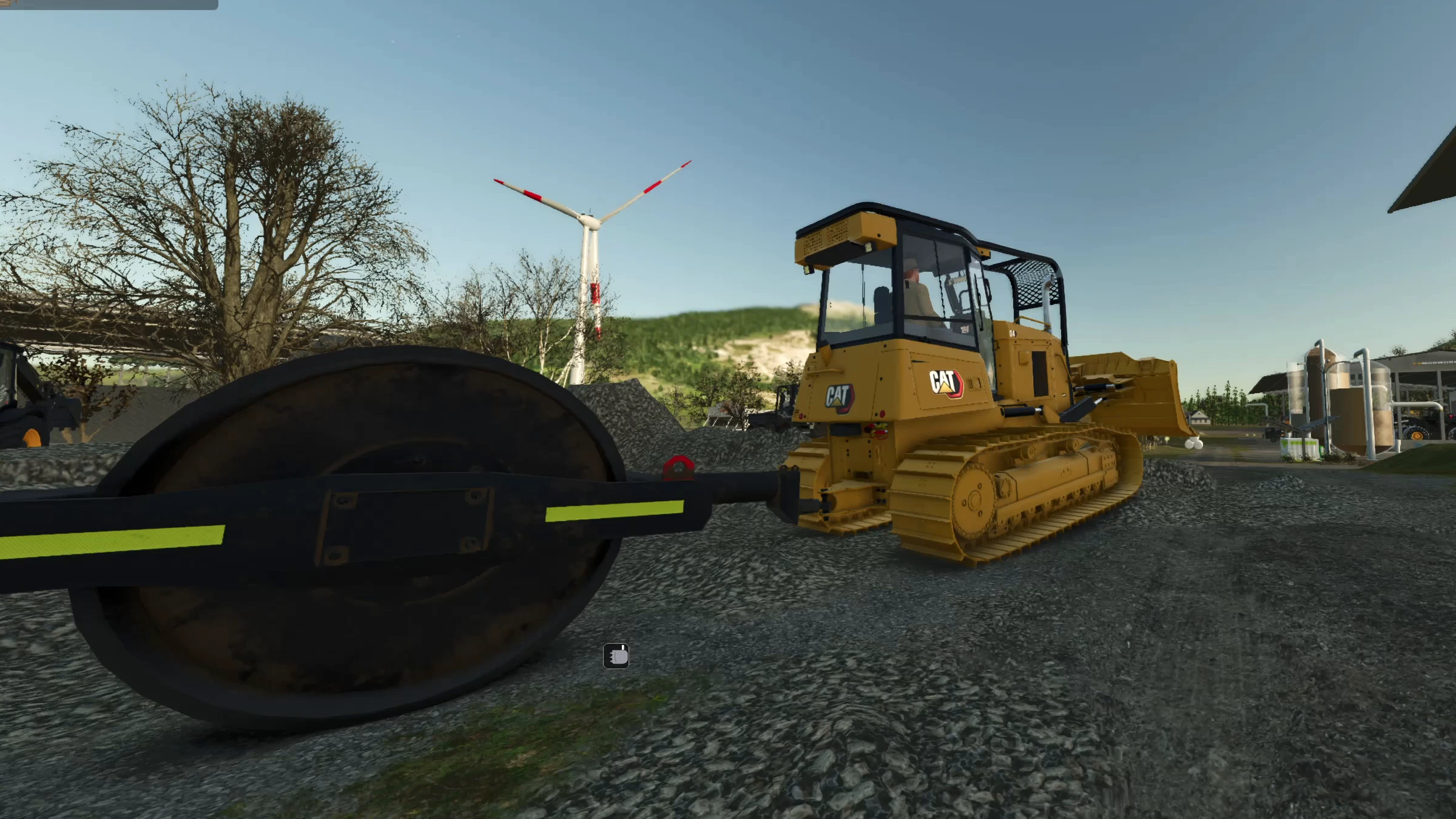 A trailed roller behind a CAT dozer smoothing a gravel surface